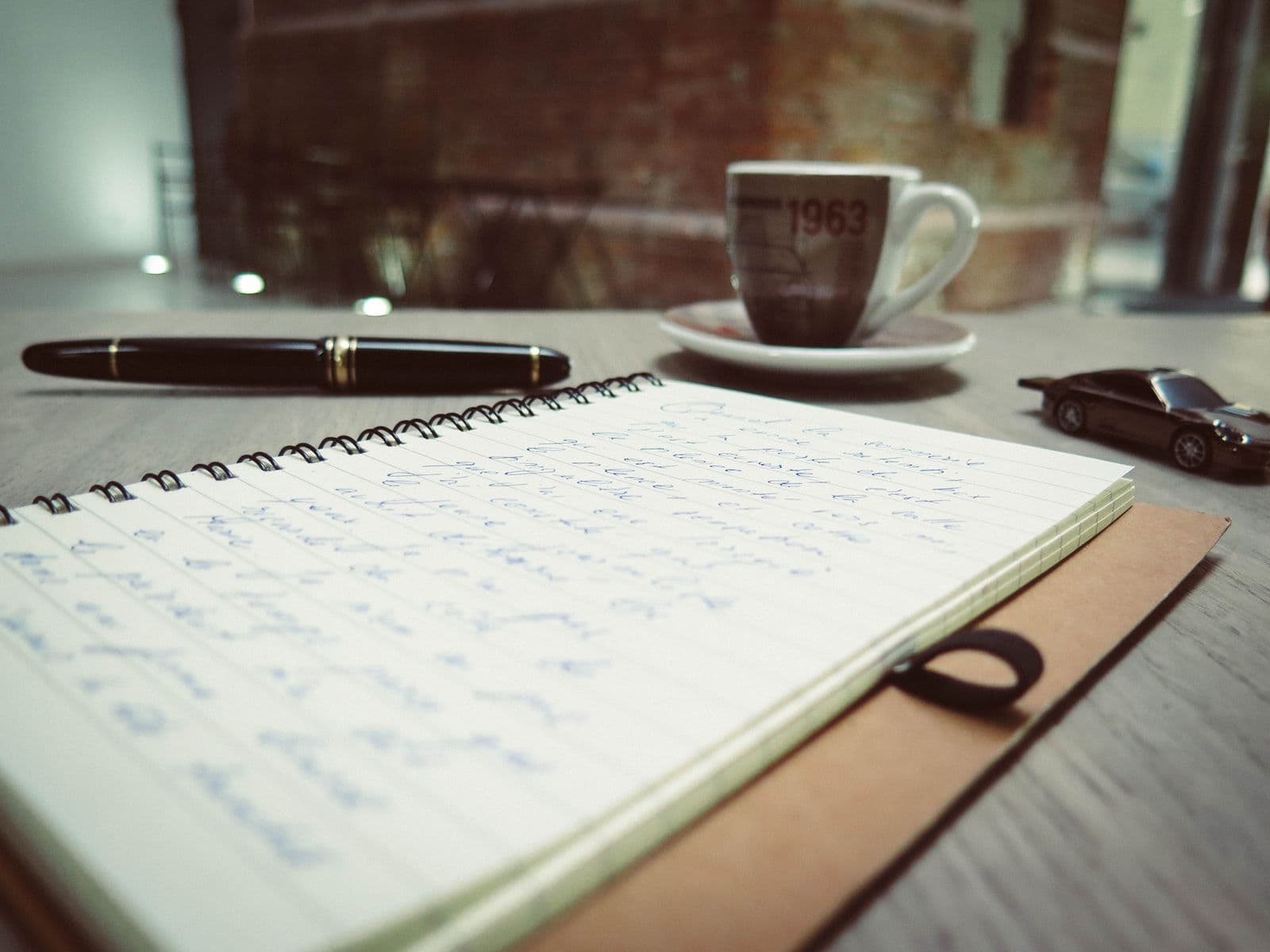 Notebook, pen and coffee on a desk
